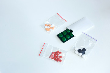 Blister with pills and little bags with tablets on  white background