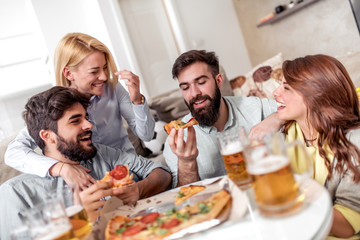 Group of friends enjoying pizza and beer