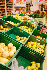 Bunch of red and green apples on boxes in supermarket