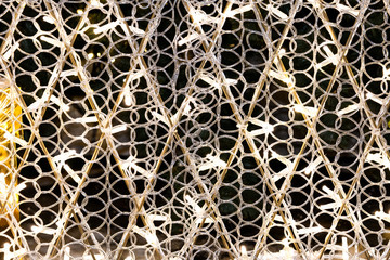 A garland of white lights wound on a metal structure in the form of diamonds.