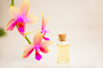Obraz na płótnie Canvas Essence of orchid flowers on table in beautiful glass jar