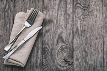 Cutlery and napkin on a wooden table with copy space. Food background