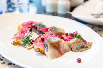 Fish herring with potatoes and red pickled onions.