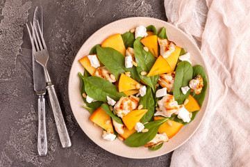 Exotic salad with spinach, persimmon, grilled chicken fillet, feta