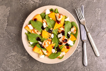 Exotic salad with spinach, persimmon, grilled chicken fillet, feta
