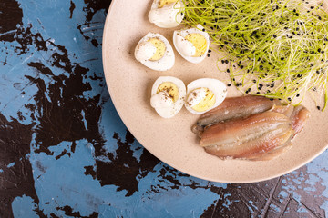 Unusual salad with leek sprouts, quail eggs and anchovies