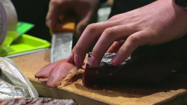 Cutting dry meat on the chopping board. Smoked beef jerky meat slices