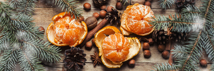 Tangerines, Christmas tree branches, cones, spices on a wooden background. Сoncept of New Year and...