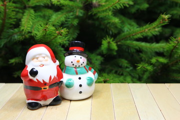 Boże Narodzenie - xmas - ceramiczny mikołaj i bałwan w tle choinka © Cezzar