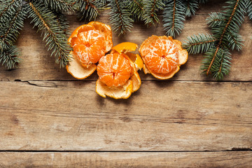 Tangerines and Christmas tree branches on a wooden background. Concept of New Year and Christmas. Flat lay, top view