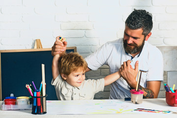 Happy family. The boy and his father are playing in the children room. Funny homework to prepare...