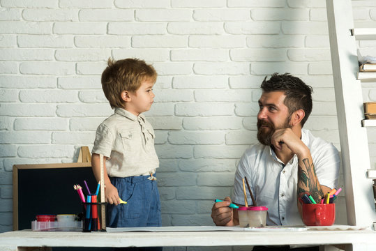 Family team, the father is engaged with his son drawing. A stylish bearded man and his little son. Responsible parent, art for teaching, home education