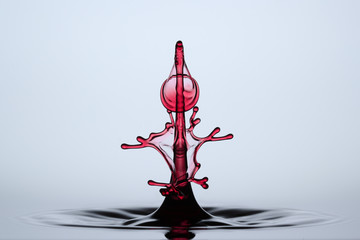 red abstract waterdrop sculpture formed after collision