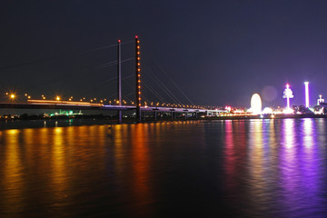 long time exposure of the rhine bridge with colorful lights of the funfair