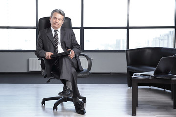 boss with a clipboard , sitting in an office. photo with copy space