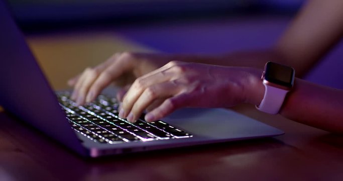 Woman type on computer at night