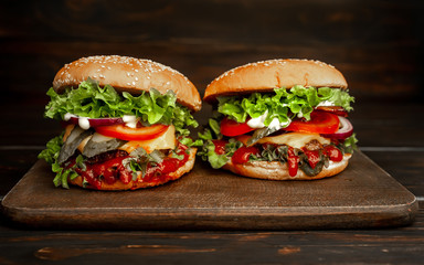 two delicious  homemade burger for slicing beef on a wooden table