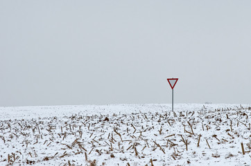 sign give way in a snowy field