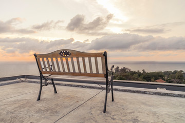 Fototapeta na wymiar rooftop bench with sea and sunset view