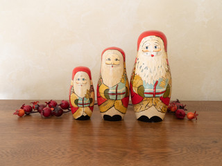 Three Handpainted Wooden Santa Claus Dolls with Red Berries