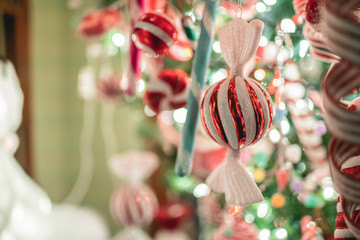 Christmas bauble decoration in a form of a candy hanging on a tree.
