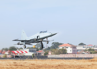 Fototapeta na wymiar Fighter jet military aircraft flying with high speed take off from runway with steam from exhaust