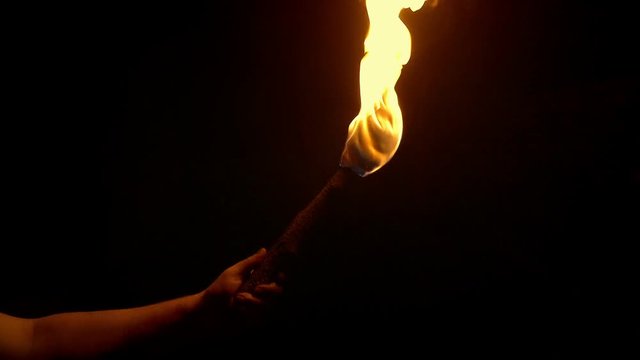 Flaming Torch Is Held Up In The Dark
