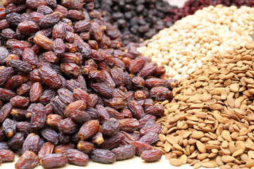 Big dried dates, raw almonds and pistachios, lying on a large counter at the market in Deira, Dubai.