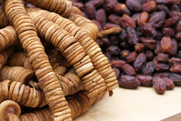 Big dried dates and dried figs strung on twine, lying on a large counter at the market in Deira, Dubai
