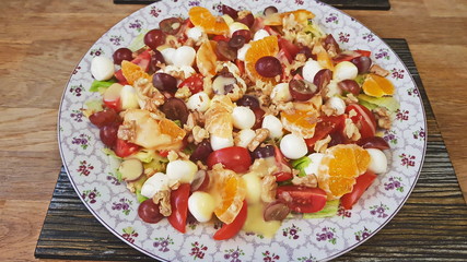 Mixed salad of tangerines, mozzarella, grapes and walnuts.