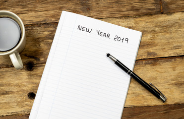 2019 New Year Resolutions written on notebook pen and coffee on wood table in Better life goals
