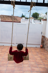 niño jugando en el columpio