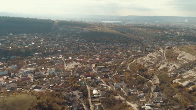 Aerial view of the city, surrounded by the rocky hills with the river in the background. Shot. Rainy autumn landscape