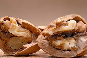 Brown premium raw organic walnuts on natural cork background.