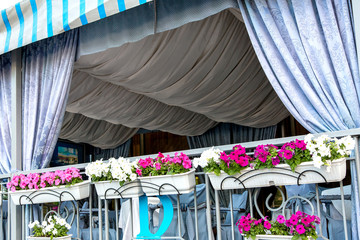 The summer terrace of the restaurant is a covered pergola decorated with curtains and draped in...