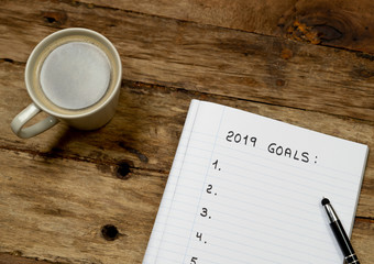 2019 Goal list copy space on notepad and coffee on wood table in New Years resolution for happy life