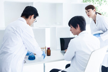 Obraz premium 研究記録をパソコンに残し実験をすすめる科学者たち