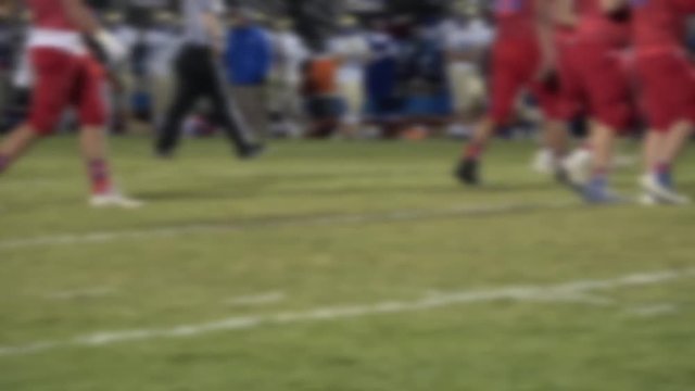 Defocused legs of running football players and refs