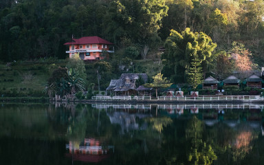 Obraz premium The Reflection of home town in the River, Riverside view at Rak Thai Village, Mae hong son, Thailand