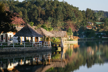 Fototapeta na wymiar The Reflection of home town in the River, Riverside view at Rak Thai Village, Mae hong son, Thailand