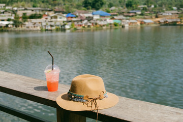 Obraz premium Feel relax by mountain view with a cup of strawberry italian soda drink and brown bohemian hat. Ruk thai mountains view in Mae Hong Sorn, north of Thailand. 