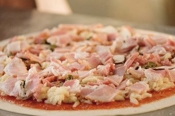 Closeup hand of chef baker in white uniform making pizza at kitchen. soft focus