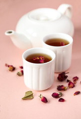 Obraz na płótnie Canvas Herbal tea with roses on pink background