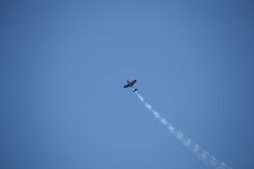 Small airplane doing aerial acrobatics in a exhibition