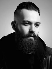 Brutal bearded hipster in vintage leather coat