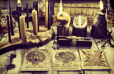 Vintage still life with black candles, key and old tarot cards. Magic ritual. Wicca, esoteric and occult background with vintage witch objects 