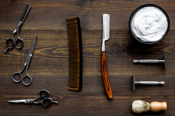 Instruments of male hairdresser barbershop top view on wooden background