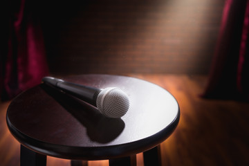 microphone on a wood stool on a stage - obrazy, fototapety, plakaty