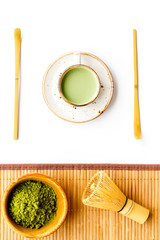 Coffee and cocktails with matcha concept. Matcha latte near bowl with matcha powder on white background with bamboo table mat top view pattern