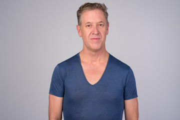 Mature man wearing blue shirt against white background